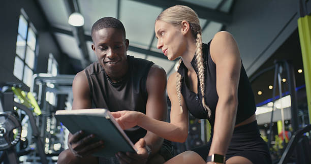 istock Fitness, man and instructor with tablet at gym for membership, training schedule or registration. Sign up, people or personal trainer with workout app for subscription plan or exercise program offer 2233174241