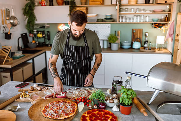 istock Putting fresh mozzarella and mushrooms on pizza before baking. 2233176887