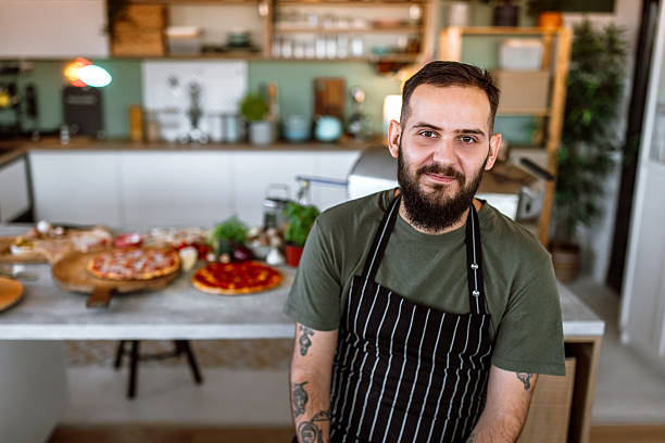 istock Portrait of a young chef with apron, in kitchen, smiling looking at camera. 2233176935