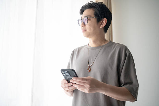 istock Young Male Using Mobile Phone at Home 2233177874