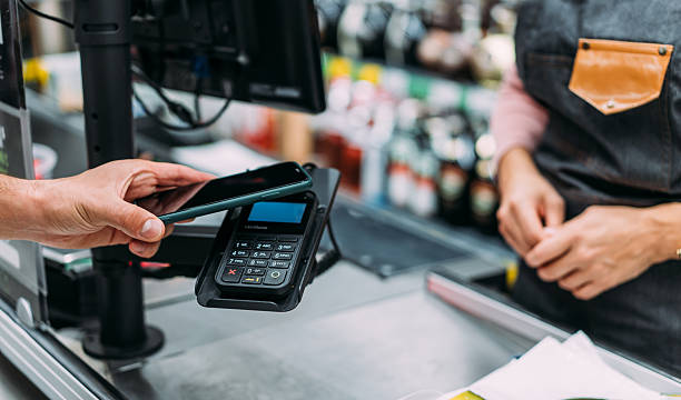 istock Man using phone to make the payment at the supermarket 2233180097