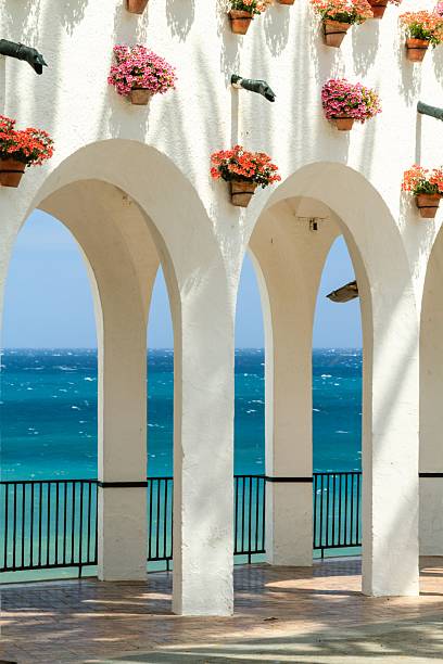 istock White arches with flowers and ocean view. 2233181949