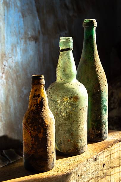 Old glass bottles with weathered textures in warm sunlight, creating a vintage feel.