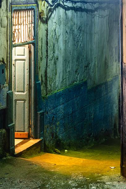 istock Mysterious illuminated alleyway with open door. 2233182087