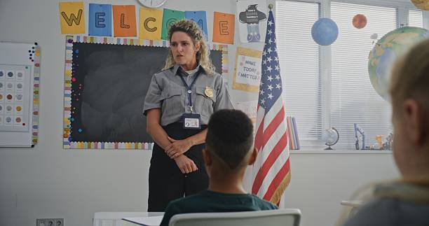 istock American Female TSA Security Officer Explaining Safety Rules to Young Students at Elementary School 2233184258