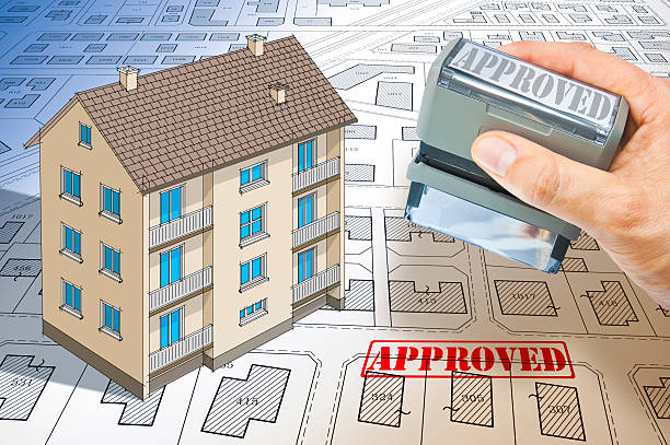 istock APPROVED BUILDINGS PERMIT CONCEPT in buildings activity and construction industry with approved residential building project, condominium residential apartments model and imaginary cadastral map 2233187251