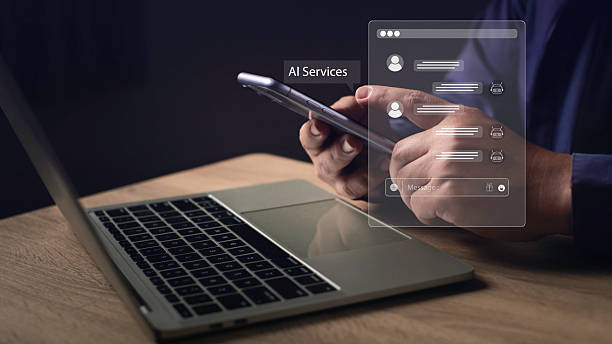istock Close-up of hands using smartphone and laptop with AI chatbot interface overlay, representing conversation assistant, customer service automation, artificial intelligence technology. 2233188088