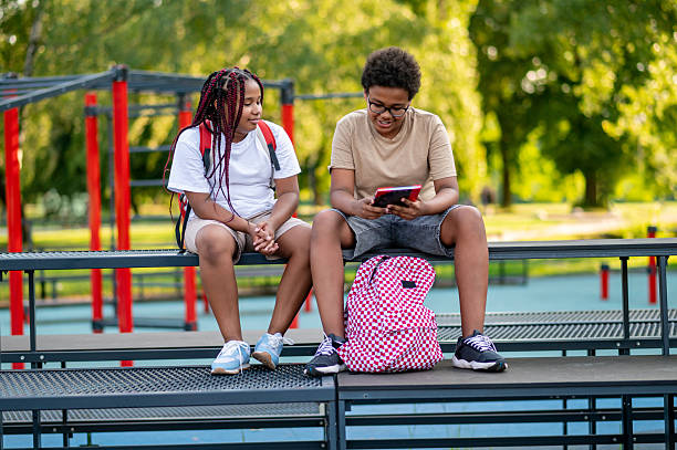 istock Teens sitting at the playground and talking 2233189245