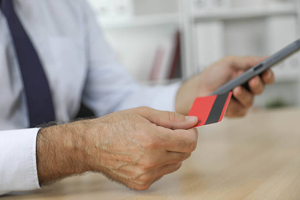 istock Mature Professional Using Bank Card and Smartphone Symbolizing E-Commerce and Tele-Finance 2233189382
