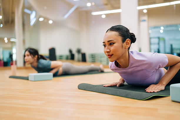 Young Asian females doing backbend yoga exercise indoors