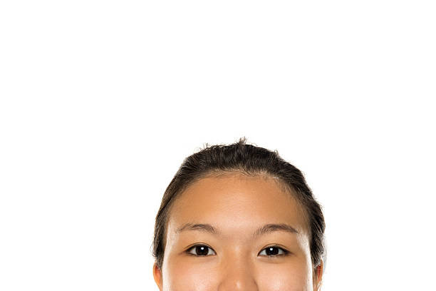 Asian woman's eyes and forehead visible with large empty white space above, studio shot on white background