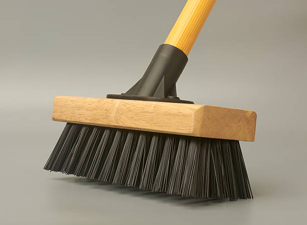 close-up scrub broom or deck brush with wooden head and black bristles isolated gray background, side view