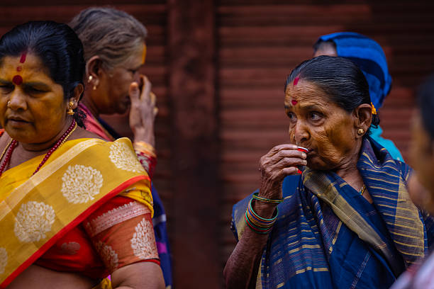 Varanasi, Uttar Pradesh, India - March 2024: Portrait of an unidentified south indian hindu woman in traditional clothes sitting on the streets of varanasi post taken the darshan of lord shiv.