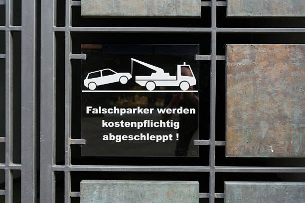Sign with the german inscription Falschparker werden kostenpflichtig abgeschleppt (Illegally parked vehicles will be towed away at the owner's expense)