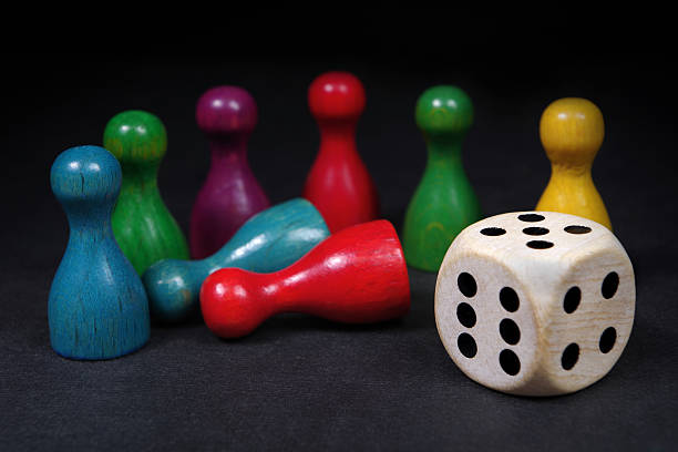istock colorful play figures with dice on black board. selective focus 2233210434