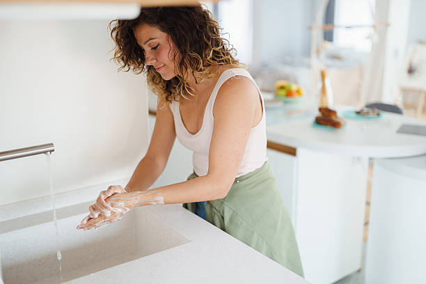 istock Young Woman Washing Hands in Modern Kitchen with Bright Natural Light 2233213960