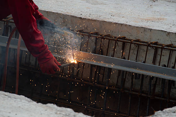 Welders are welding steel at a construction site.