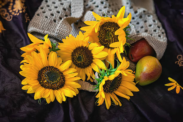 Eco friendly reusable mesh bag with sunflowers and fresh fruit, zero waste lifestyle, natural beauty in everyday life. Concept of eco living, reusable bag, sustainable lifestyle, organic food