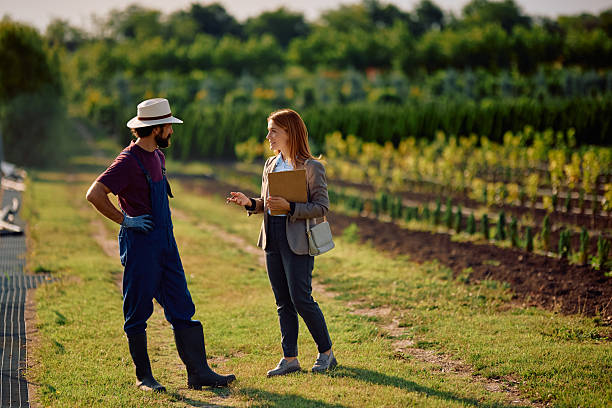 Happy insurance agent communicating with a farm field owner.