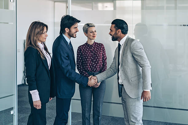 istock Business persons handshaking during a meeting in modern office 2233235655