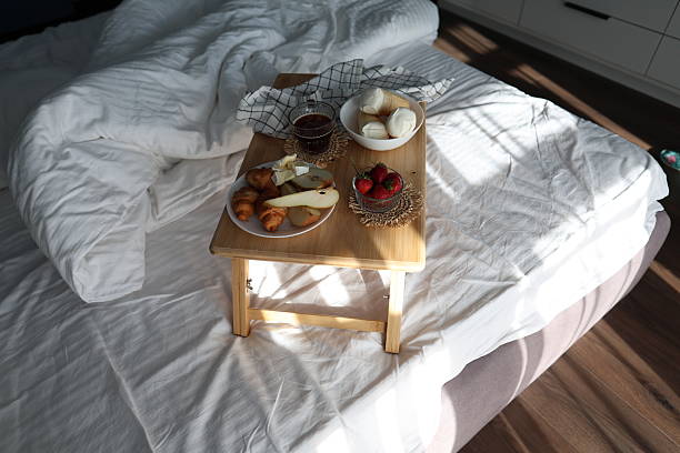 istock Cozy Breakfast in Bed With Croissants, Fruit, Cheese, Coffee, and Ice Cream Cones 2233237349