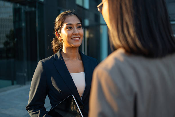 istock Two businesswomen talking outside office building 2233239317