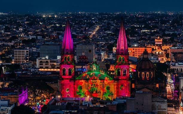 Night view of Guadalajara Cathedral illuminated with colorful lights, showcasing vibrant cityscape and architectural beauty.