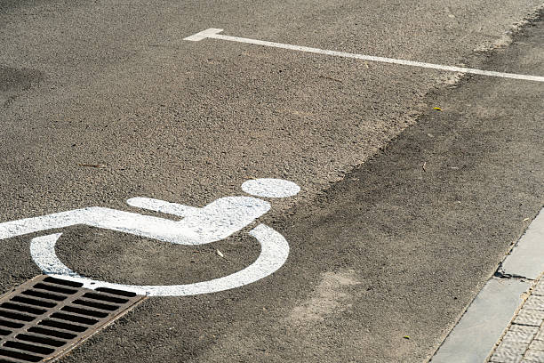 istock Accessible parking space marking located on a pavement in a public area during daytime with sunlight reflecting off the ground 2233242989
