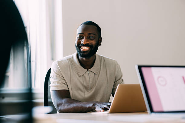 istock Smiling Professional Using a Laptop in a Bright Office Environment 2233243026
