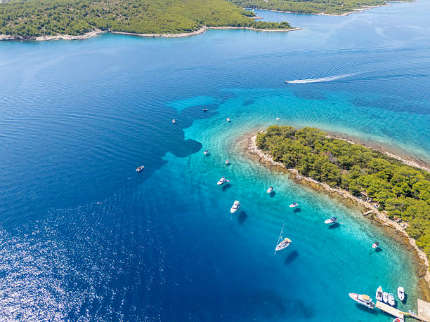 istock Boats Anchored Near Small Forested Island 2233245580