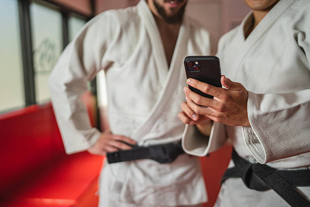 istock Two martial arts athletes using smart phone in gym 2233249958