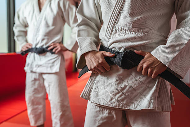 istock Martial arts athletes adjusting black belt during practice 2233249960