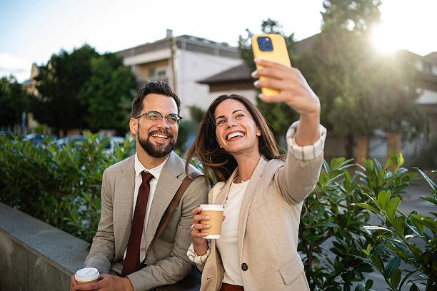 istock Business people taking selfie while having coffee break outdoors 2233249977