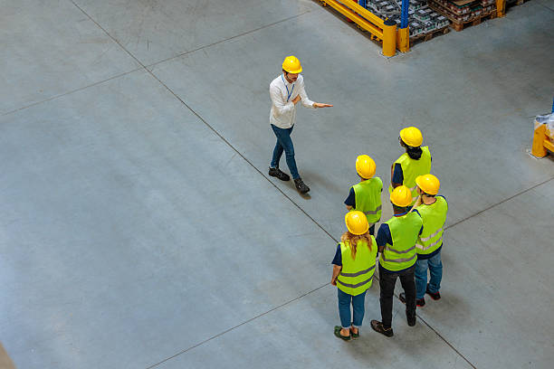 istock Warehouse manager explaining something to a group of warehouse workers 2233250126