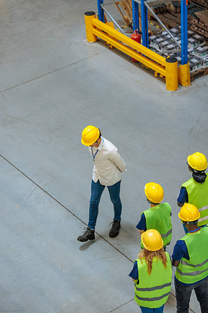 istock Worried manager walking in front of warehouse workers 2233250130