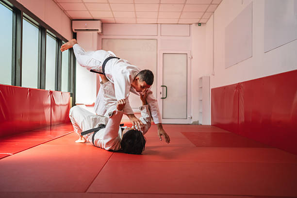 istock Two martial artists performing judo throw in training hall 2233250201