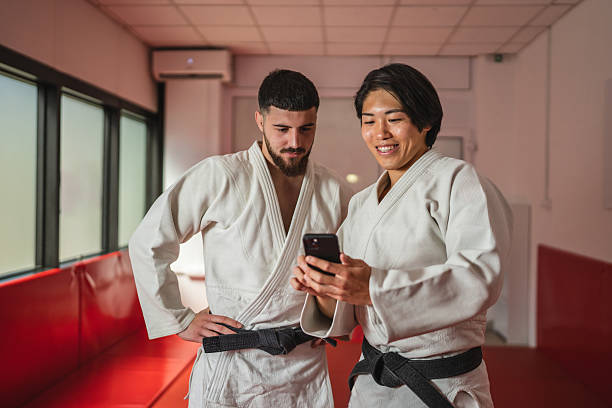istock Male judo athletes using smart phone in training room 2233250249