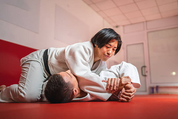 istock Determined male judo athlete performing arm lock on male opponent during training 2233250470