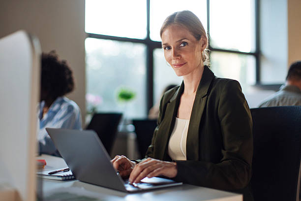 istock Professional Woman Using Laptop in Modern Office with Focused Expressions 2233252510