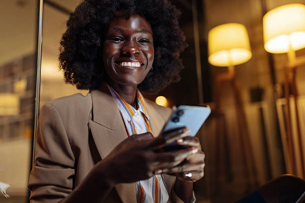 istock Smiling Professional Woman Using Smartphone in Modern Office Setting 2233252515