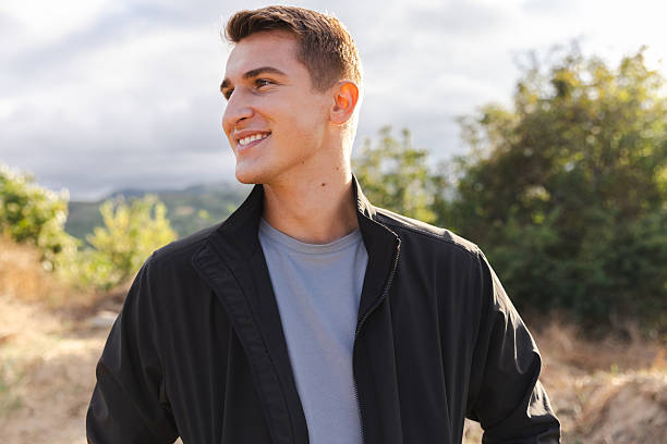 istock Young Man Smiling Outdoors in a Scenic Natural Setting 2233254557