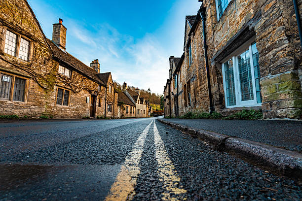 Low angle view of double yellow no parking lines on a street in castle combe, a picturesque village in the cotswolds, england
