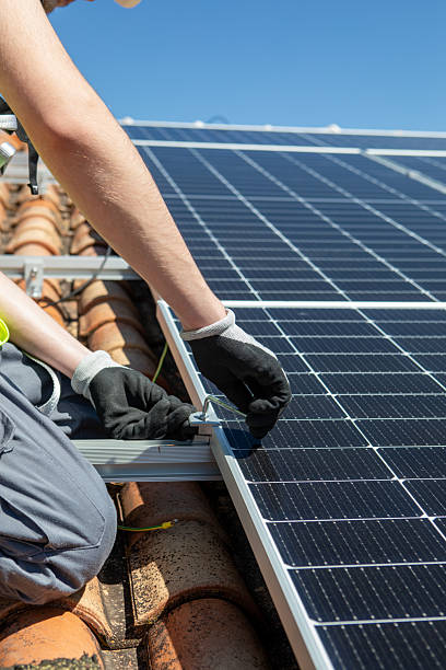 istock A skilled worker is focused on installing solar panels on a rooftop during a sunny day. The clear blue sky enhances the vibrant scene of renewable energy work. 2233257484