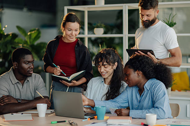 istock Diverse business team collaborating on project using laptop in modern office 2233257656