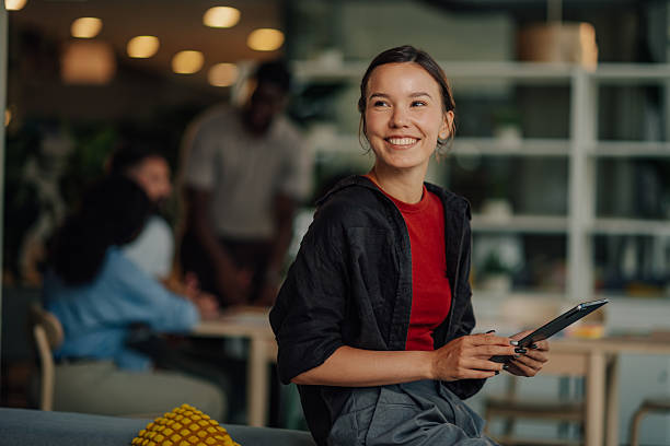 istock Young business woman smiling and using digital tablet in modern office 2233257702