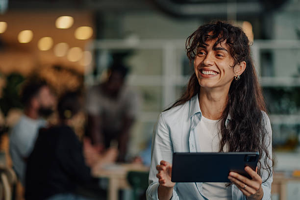 istock Young businesswoman smiling and using digital tablet in modern office 2233257727