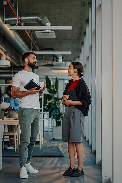 istock Coworkers chatting during break time in modern office 2233257770