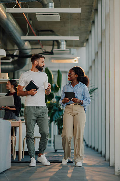 istock Business colleagues walking and talking in modern office 2233257772