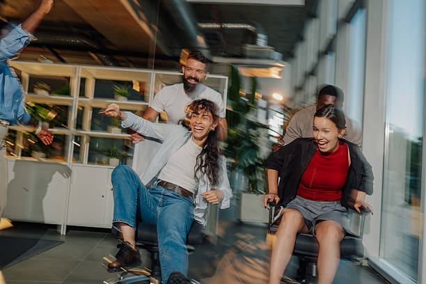 istock Coworkers having fun racing on office chairs 2233257792