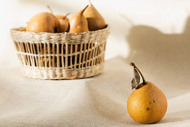 istock Ripe golden pears nestled in a wicker basket, 2233258530